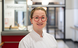 Frau mit Brille, Haare zusammen im Flur