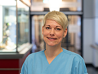 Frau mit kurzen blonden Haaren im Flur