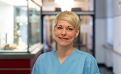 Frau mit kurzen blonden Haaren im Flur