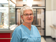 Frau mit kurzen grauen Haaren und Brille
