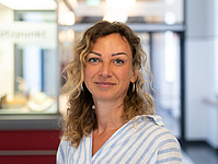 junge Frau mit blonden Locken im Flur
