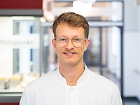 Mann mit Brille vor Fenster