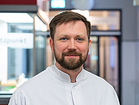 Junger Mann mit Bart im Flur